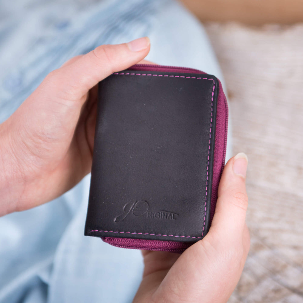 Kleine Geldbörse mit Reißverschluss in der Hand